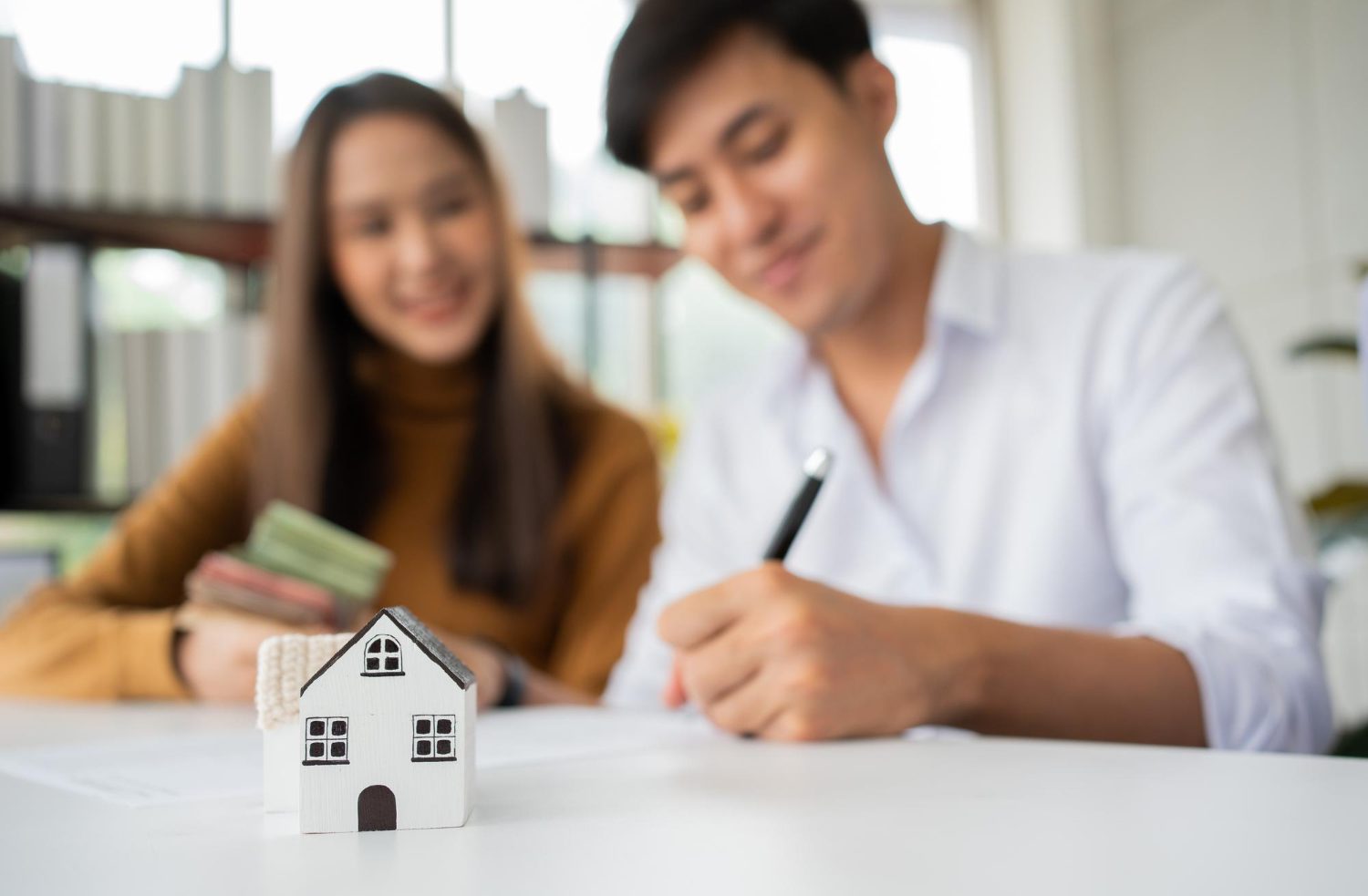 A couple reviewing mortgage eligibility and home loan eligibility criteria with a banker for their property purchase in Singapore.