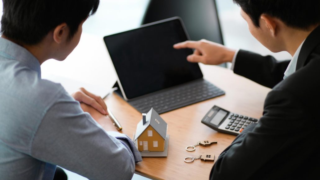 Young workers reviewing documents to check mortgage eligibility before applying for their first HDB flat in Singapore.